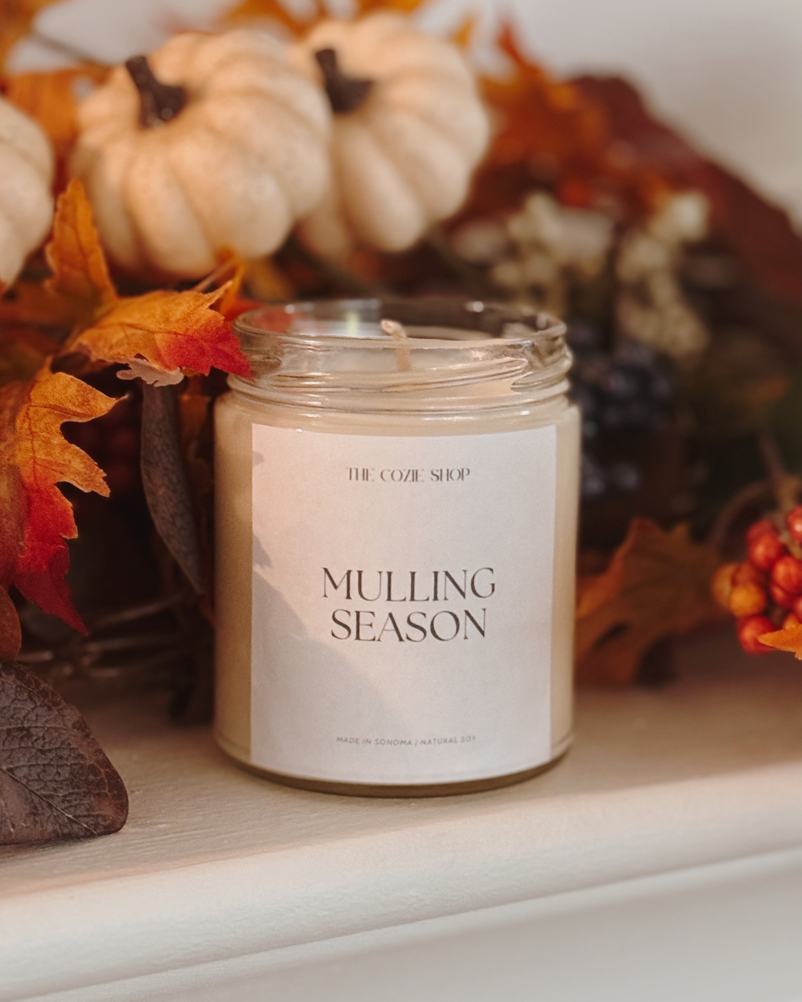Candle labeled 'Mulling Season' with autumn decorations in the background